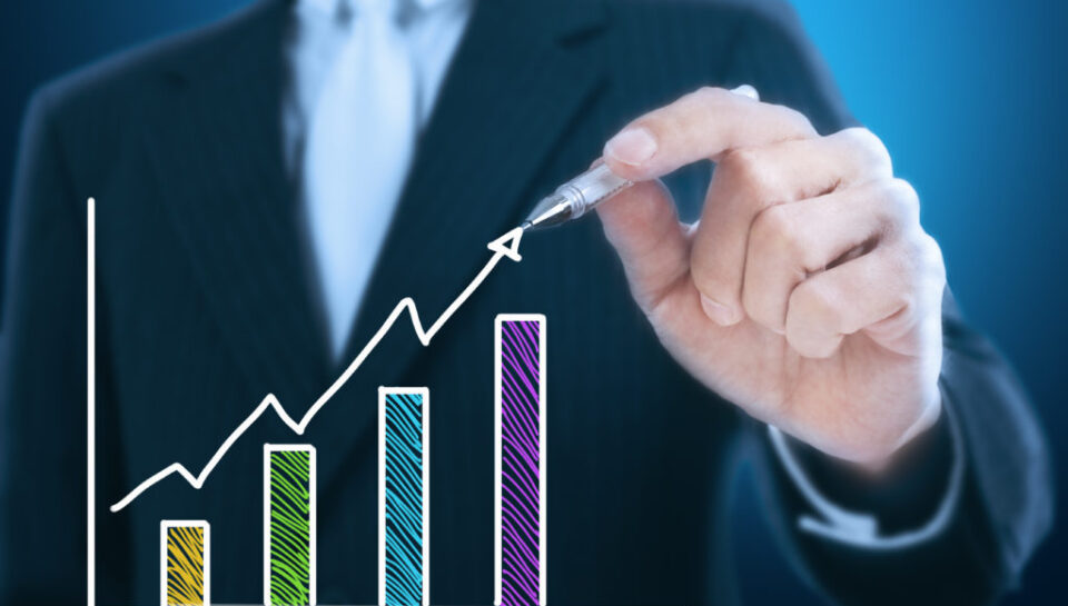 businessman writing rising graph ,blue background