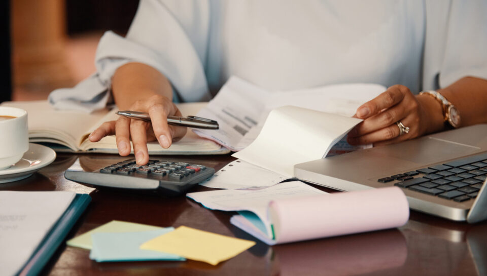 Hands of female entrepreneur working with bills and documents