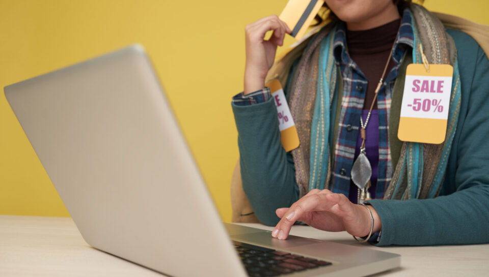 Woman sitting at desk and using laptop to do online shopping during sales