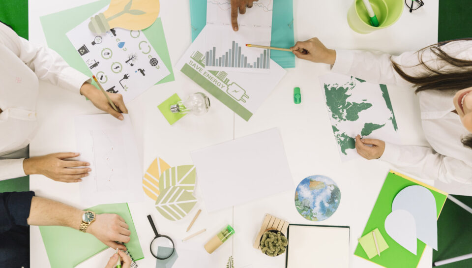 empresarios-que-trabalham-no-grafico-com-varios-recursos-naturais-icone-na-mesa